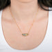 Boulder opal necklace with gold chain on a person