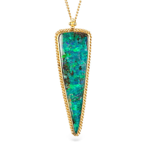 Triangle-shaped boulder opal stone pendant with a gold setting on a white background