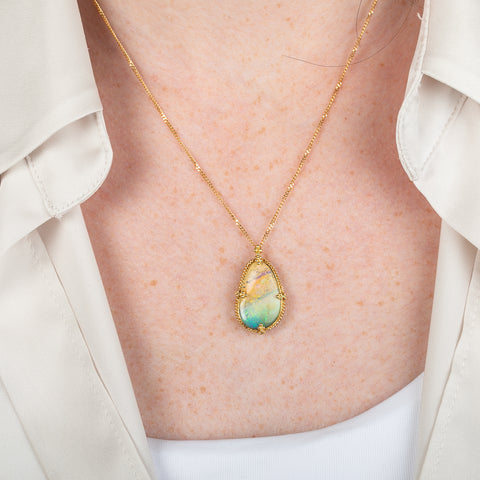 18k gold necklace featuring a boulder opal gemstone worn on a person