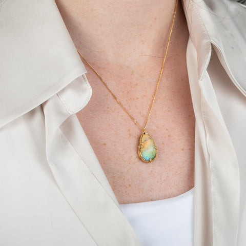 18k gold necklace featuring a boulder opal gemstone worn on a person