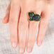 Hand wearing a labradorite cat ring with an 18k gold bezel and sterling silver band