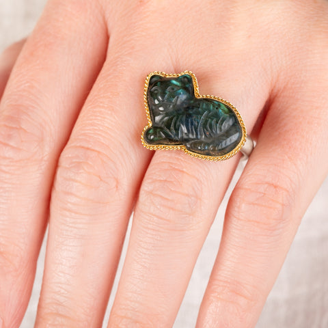 Close up of a hand wearing a Labradorite cat ring with an 18k gold bezel and sterling silver band