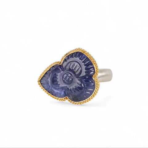 Handmade fine jewelry ring with carved tanzanite stone set in gold and complete with sterling silver band