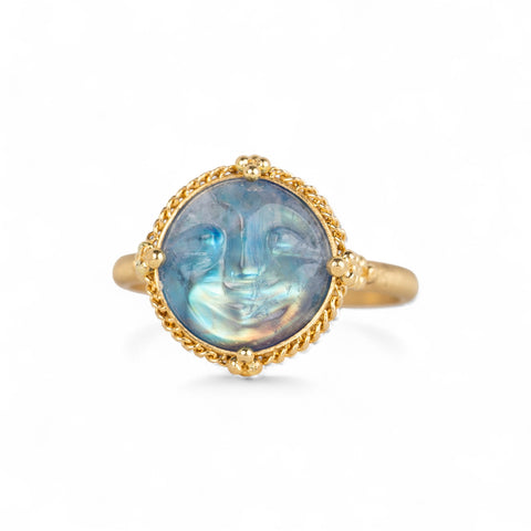 Gold ring with a carved moonstone on a white background