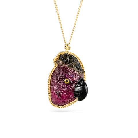 Gold necklace featuring a carved tourmaline parrot pendant on a white background