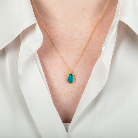 Australian opal and 18k gold necklace on a person