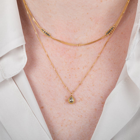 Gold necklace with a natural-colored diamond on a person