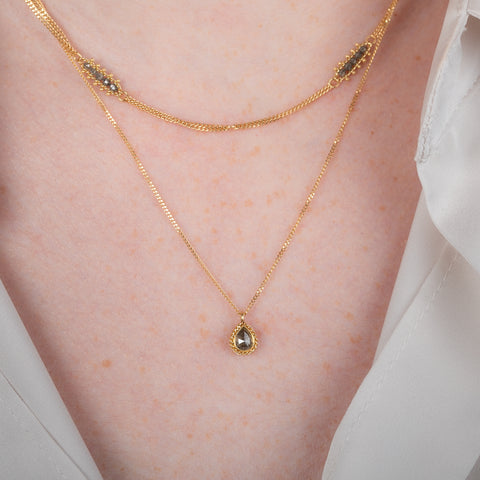 Handmade gold necklace with a natural-colored diamond on a person