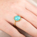 Gold ring with a turquoise stone on a person's finger