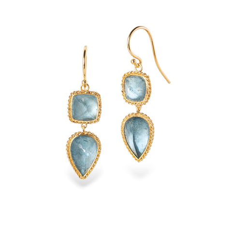 Gold earrings with blue aquamarine gemstones on a white background
