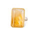 Ring with a large citrine stone, gold setting and silver band on a white background