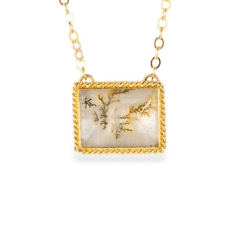 Gold-framed dendritic quartz pendant necklace on a white background