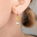 Gold earrings with diamonds worn by a person