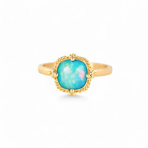 Gold ring with an Ethiopian opal stone on a white background