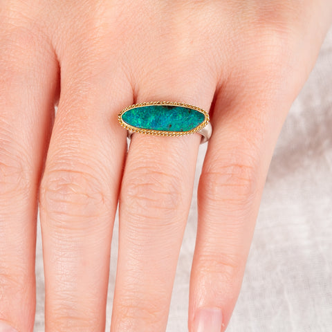 Hand wearing a boulder opal ring with an 18k gold bezel and sterling silver band