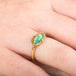 Gold ring with an Ethiopian opal stone on a person's finger