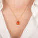 Gold necklace with a fire opal gemstone on a person