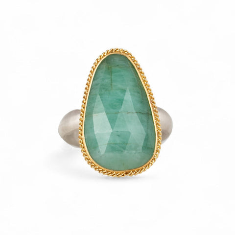 Ring featuring an emerald gemstone set in an 18k gold bezel with a silver band 