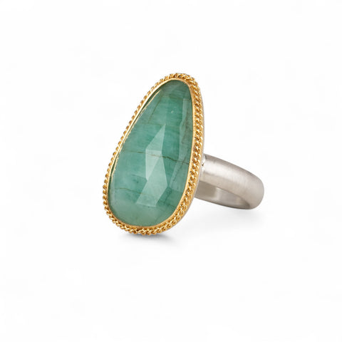 Ring featuring an emerald gemstone set in an 18k gold bezel with a silver band 