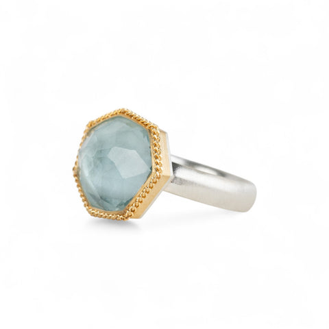Aquamarine ring with 18k gold bezel and sterling silver band on white background
