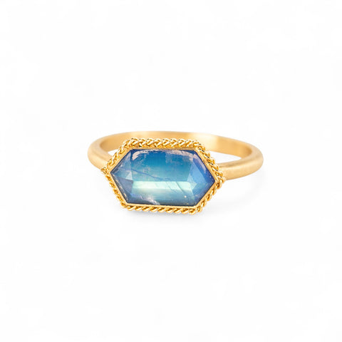 Gold ring with a moonstone gemstone on a white background