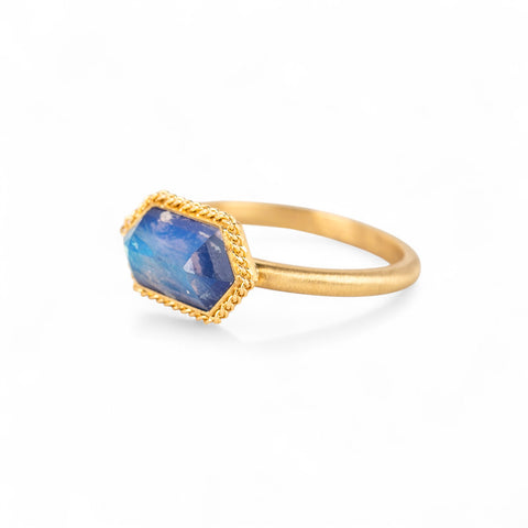 Gold ring with a moonstone gemstone on a white background