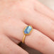Gold ring with a moonstone gemstone on a person's finger