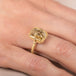 Gold ring with a dendritic quartz stone on a person's finger
