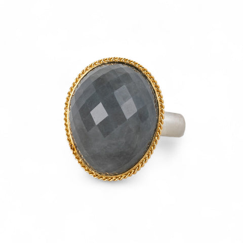 Ring with gray quartz stone, gold bezel and silver band on a white background
