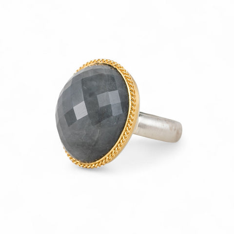 Ring with gray quartz stone, gold bezel and silver band on a white background