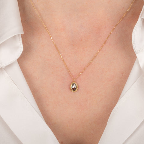 Gold necklace with brown diamond stone on a person