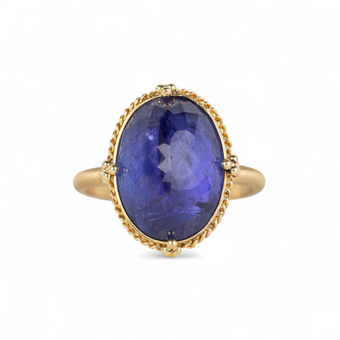 Gold ring with a large tanzanite gemstone on a white background