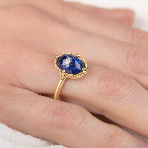 Gold ring with a blue tanzanite gemstone on a hand
