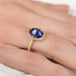 Gold ring with a blue tanzanite gemstone on a hand