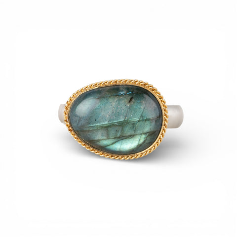 Ring with a gold bezel, silver band and labradorite stone on a white background