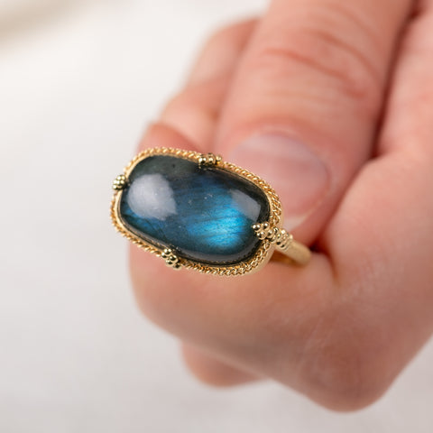 Close up of a gold ring with a labradorite gemstone