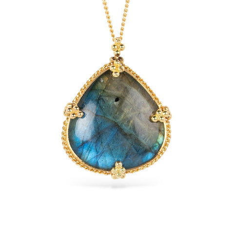 Necklace with a labradorite gemstone and gold frame on a white background