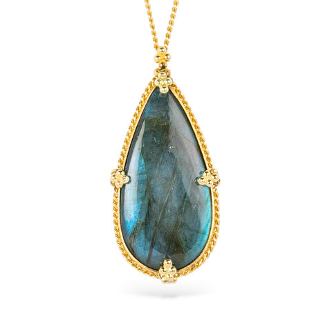 Teardrop-shaped labradorite pendant with gold frame on white background