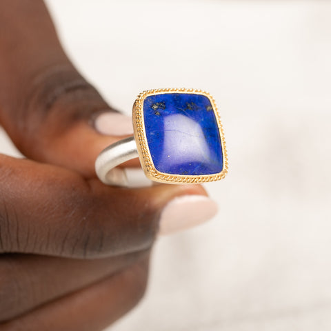 Gold and silver ring with a lapis stone held in hand