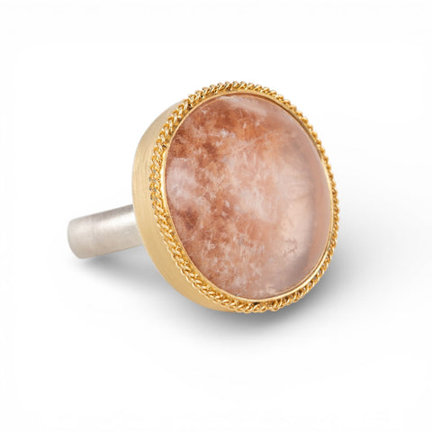 Ring with gold bezel, silver band and lodolite stone on a white background