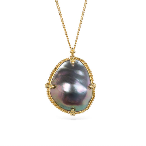 Mabe pearl pendant necklace with gold setting on a white background