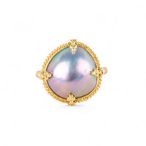 Gold ring with a mabe pearl on a white background