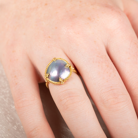 Gold ring with a mabe pearl on a hand