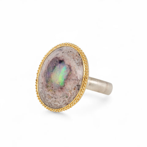Handmade fine jewelry ring with a Mexican Opal stone, gold bezel and sterling silver band on a white background