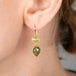 Gold earrings with diamonds worn by a person