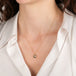 Gold necklace with a brown diamond pendant on a person wearing a white shirt