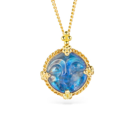 Gold necklace with a moonstone carved into a moon face on a white background