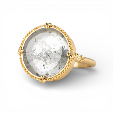 Ring with gold band and gray topaz stone on a white background