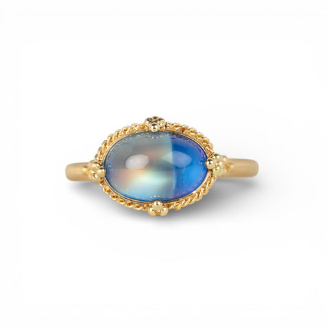 Gold ring with a moonstone on a white background