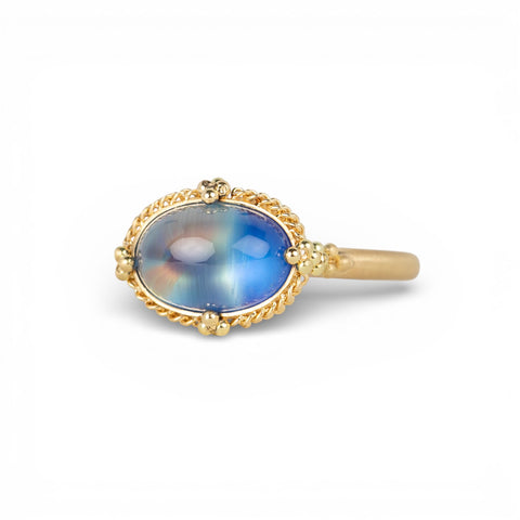 Gold ring with a moonstone on a white background